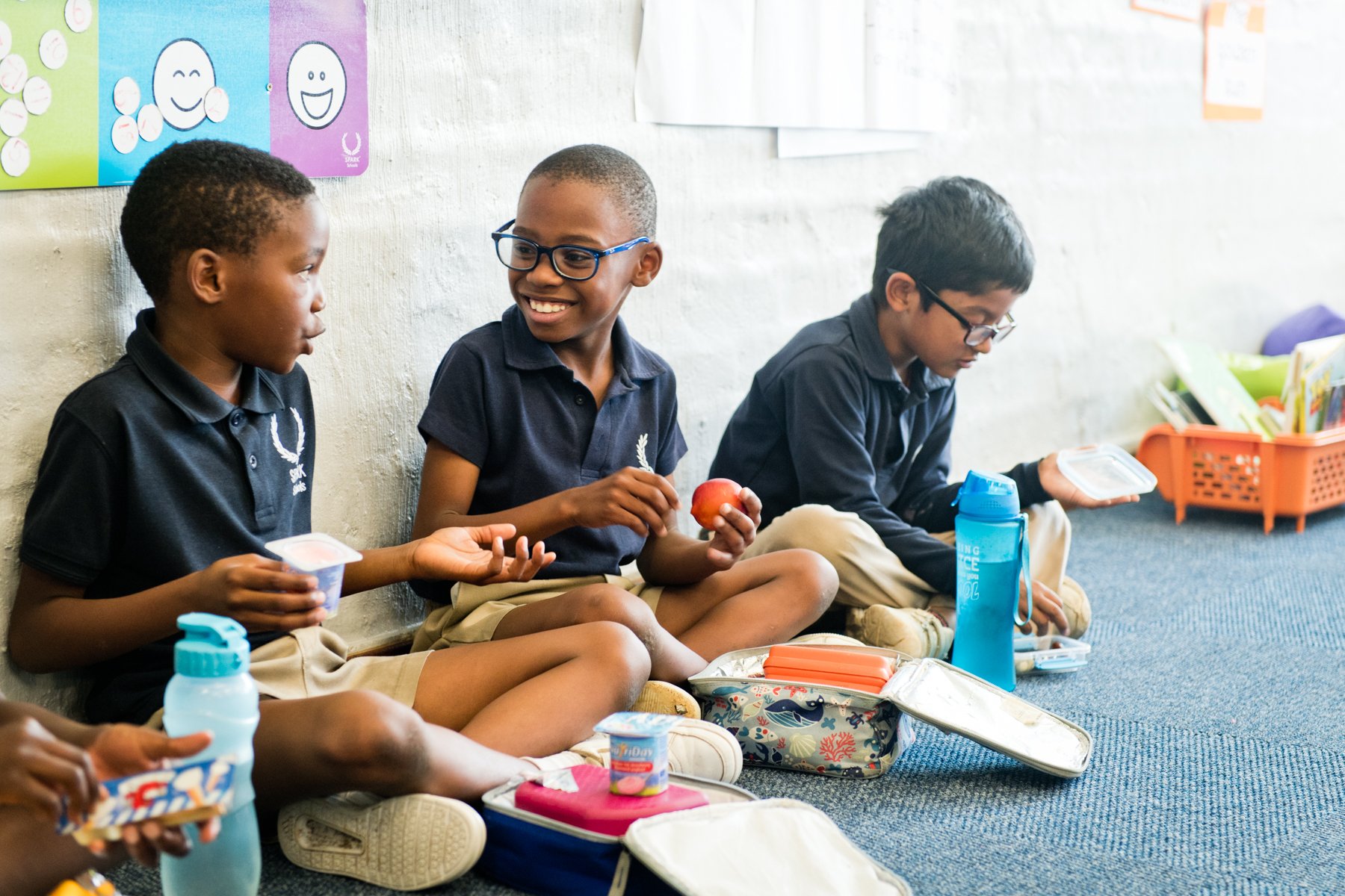 Drei Schüler:innen an SPARK-Schulen beim gemeinsamen Mittagessen.