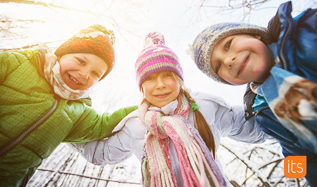 drei lachende Kinder, draußen im Schnee